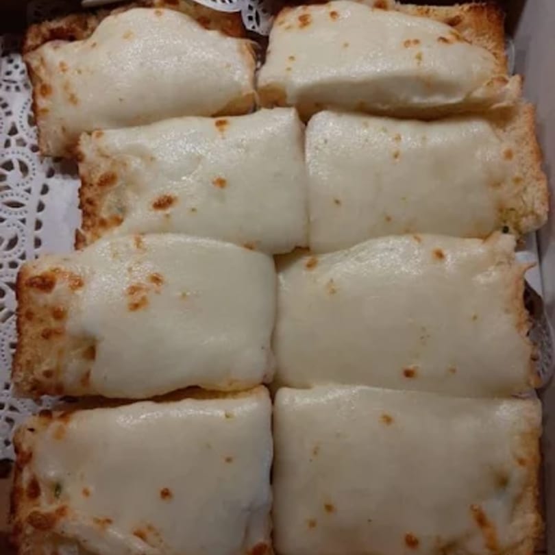 Eight rectangular pieces of cheesy garlic bread with melted white cheese and golden-brown edges.
